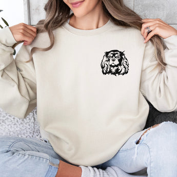 Sand Cavalier King Charles Spaniel sweatshirt with a black Cavalier silhouette modeled by a woman sitting on a couch.