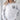 Gray Coton de Tulear sweatshirt modeled by a woman standing in a living room.