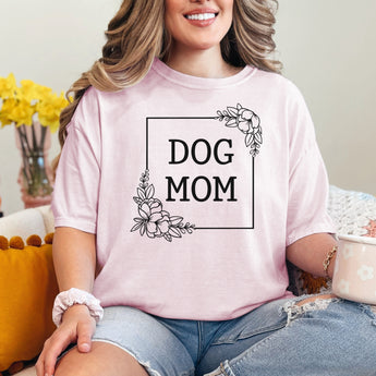 Light pink floral dog mom shirt modeled by a woman sitting on a couch holding a floral mug.