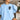 Irish Water Spaniel light blue sweatshirt modeled by a woman sitting on a couch in a living room.