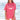 Pink dachshund summer shirt with a graphic of a dachshund running in front of the ocean and a sunset modeled by a woman standing on the beach in front of the ocean.
